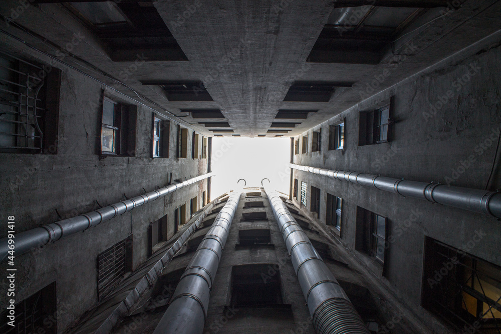 Obraz premium Bottom-up view from the courtyard-well of a historic house with closed walls in St. Petersburg Russia