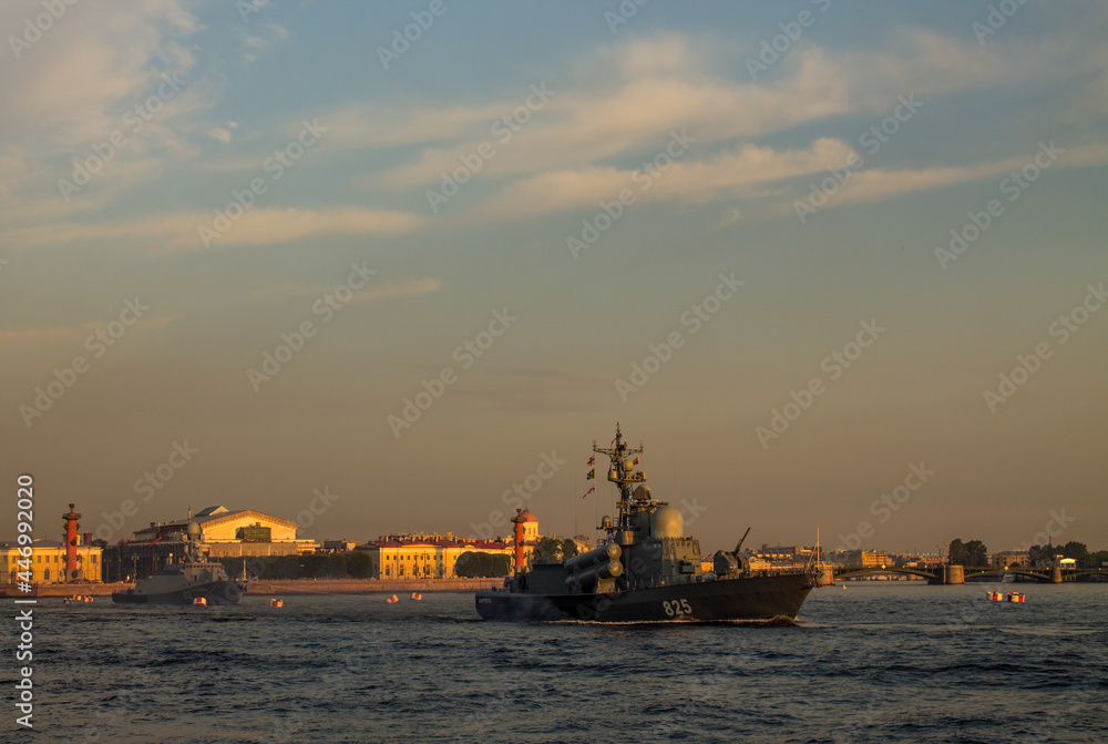 St. PETERSBURG, RUSSIA-JULY, 15, 2021: a warship sailing along the Neva River at dawn against the background of the embankment and historical architecture in the early summer morning