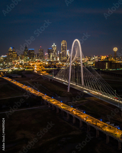 wide drone shot of downtown dallas skyline with large bridge in foreground