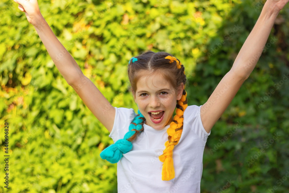 a cheerful girl with blue and yellow hair rejoices in victory. the concept of sports, competitions, support, victories. a cheerful girl with blue and yellow hair rejoices in victory. the concept of sports, competitions, support, victories.