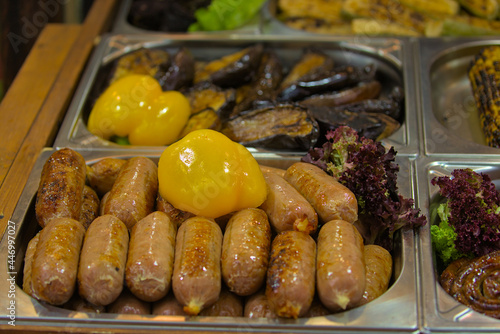 Healthy street food to go - sausages, meat, yellow bell peppers, lettuce, and other foods. Delicious food cooked over an open fire, which is offered at a street food fair, event, festival.