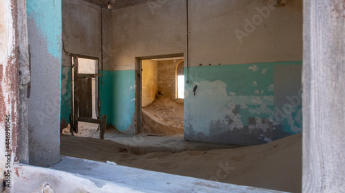 Inside of a sandfilled room at one of the houses framed by a windowframe at the ghost town of Kolmanskop, Namibia © Fearless on 4 Wheels