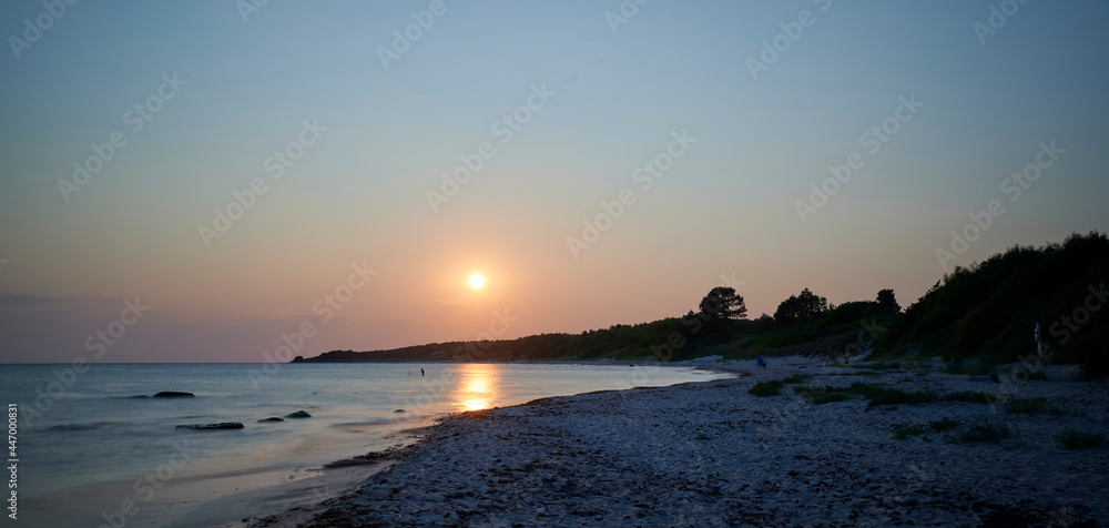 Sommerlicher Sonnenuntergang am Stand im Süden der dänischen Ostsee-Insel Bornholm in der Nähe der Ortschaften Øster Sømarken und Vester Sømarken.
