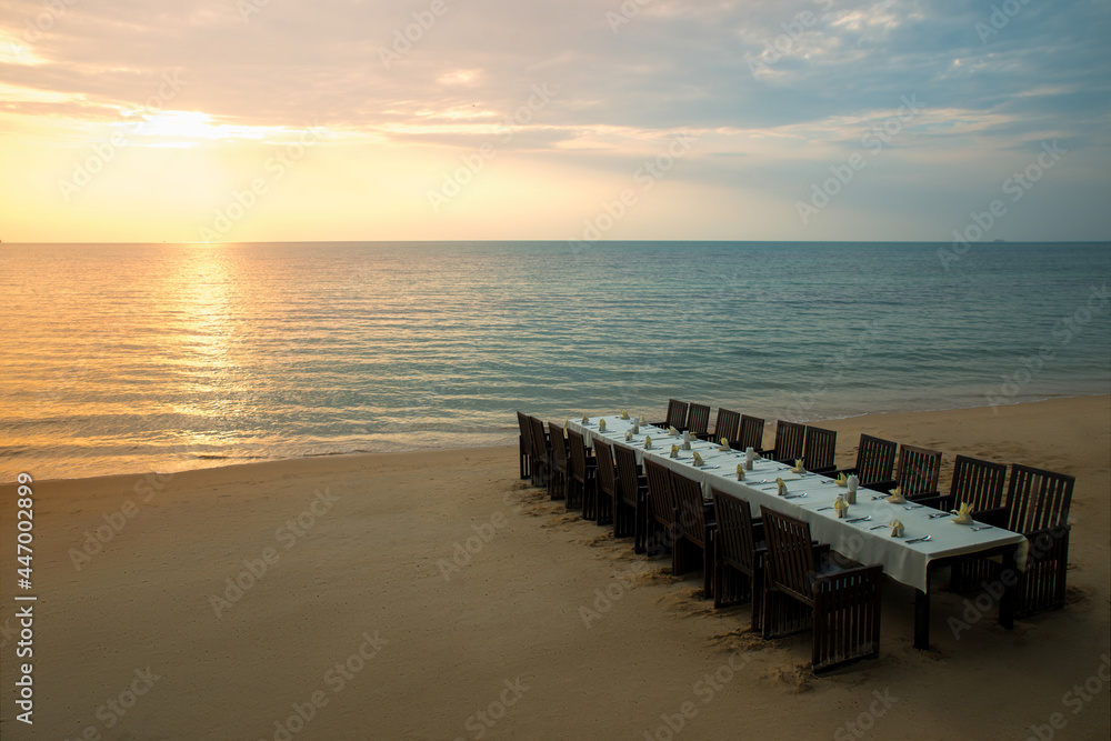 Table setting for a romantic festive dinner at sunset on the sea. Wedding or celebrating decoration Table setting for a romantic festive dinner at sunset on the sea. Wedding or celebrating decoration