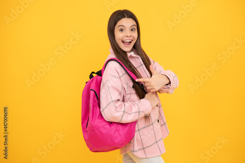 back to school. surprised teen girl in checkered shirt. happy kid casual style carry backpack.