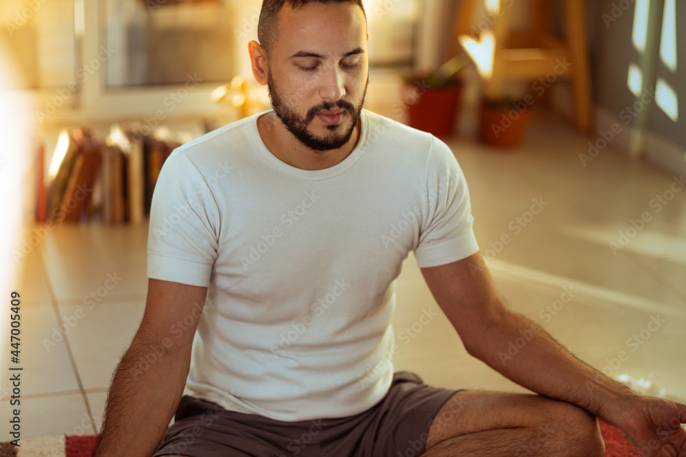 Joven se dispone en su hogar a hacer ejercicios de estiramiento relajación y yoga Joven se dispone en su hogar a hacer ejercicios de estiramiento relajación y yoga