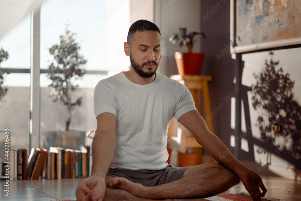 Joven se dispone en su hogar a hacer ejercicios de estiramiento relajación y yoga Joven se dispone en su hogar a hacer ejercicios de estiramiento relajación y yoga