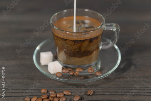Zalewanie zaparzonej czarnej kawy mlekiem.