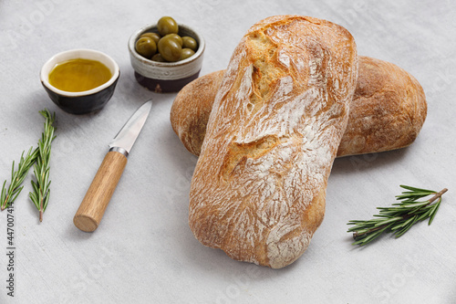 Artisan sourdough ciabatta bread with olives and rosemary on a concrete table. Freshly baked artisan ciabatta bread  photo