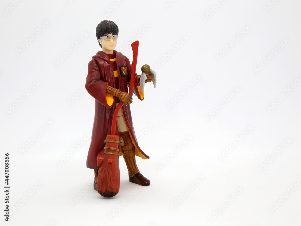 Harry Potter dressed in Hogwarts school uniform of quidditch game.  Collectible toy for children. Character from the J. K. Rowling. Broom.  Golden snitch ball. foto de Stock | Adobe Stock