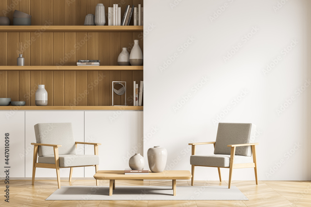 Fototapeta premium Armchairs near light beige living room wall with bookcase