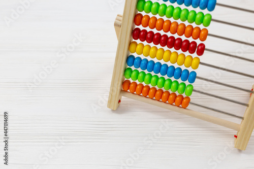Wooden colorful abacus on wooden background. Back to school  education. Tool for calculation in kindergarten  preschool