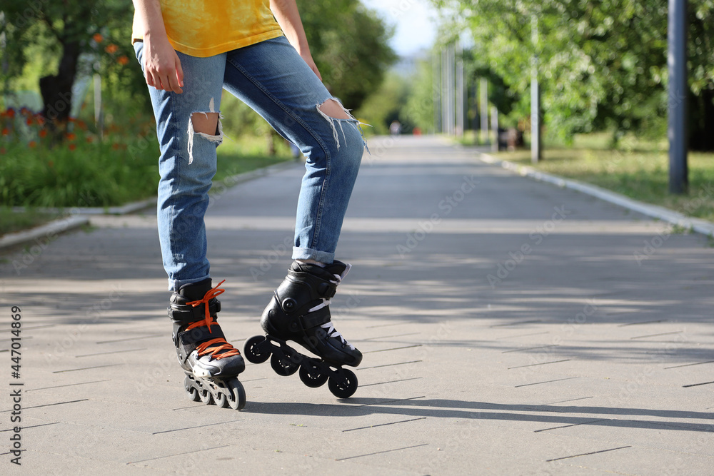 Girl posing while standing on rollers. Female feet close up background of a summer park. Roller skates inline skating outdoors. Active lifestylel.. Girl posing while standing on rollers. Female feet close up background of a summer park. Roller skates inline skating outdoors. Active lifestylel..