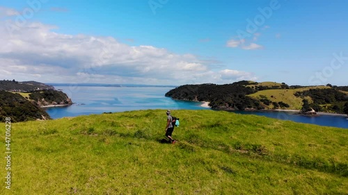 Man enjoying a walk on picturesque island aerial tracking. Bay of Island tropical coastal scenery, New Zealand photo