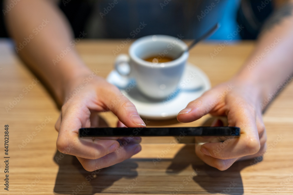 female hands with a cellphone on a table with coffee female hands with a cellphone on a table with coffee