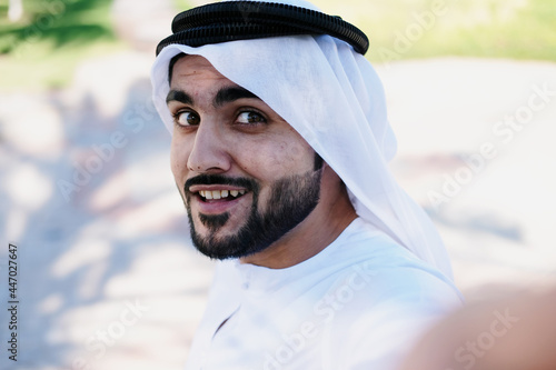 Happy Emirati Arab man. Arabic guy wearing Kandoora Dishdash in the Middle East