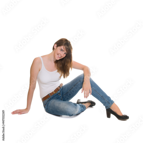 Portrait of a laughing young woman wearing blue jeans and a summer top, isolated on white studio background