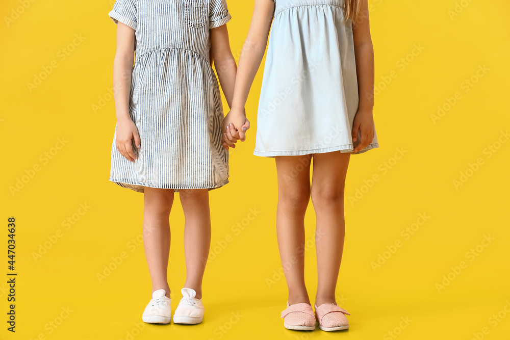 Cute little sisters on color background Cute little sisters on color background