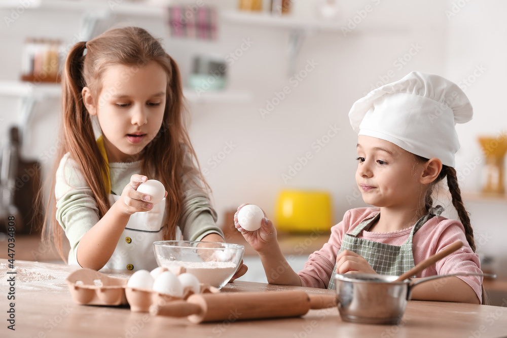 Cute little sisters cooking in kitchen Cute little sisters cooking in kitchen