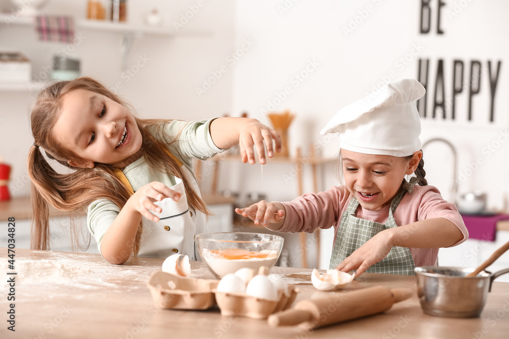 Cute little sisters cooking in kitchen Cute little sisters cooking in kitchen