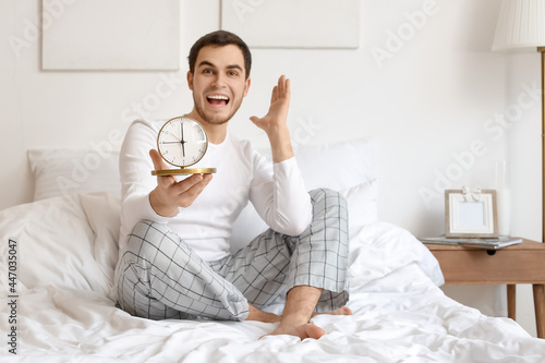 Happy young man with alarm ...
