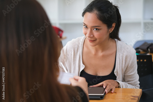 Closed up with two female talking about business plan while the main subject using tablet.