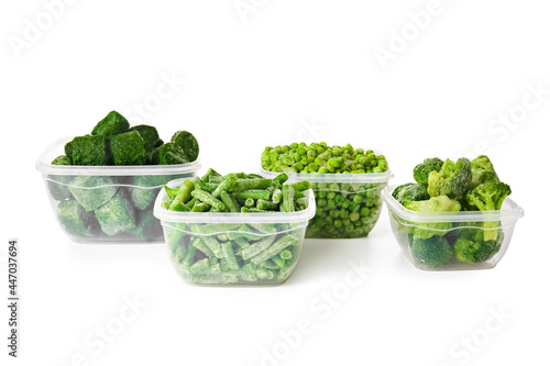 Containers with frozen green vegetables on white background