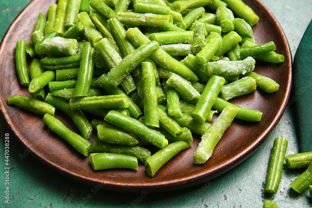 Plate with frozen green beans on color background Plate with frozen green beans on color background