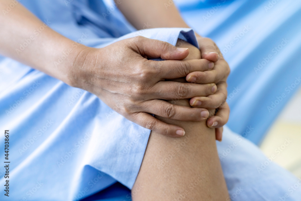 Selective focus on patient's knee that sitting on the bed in the hospital