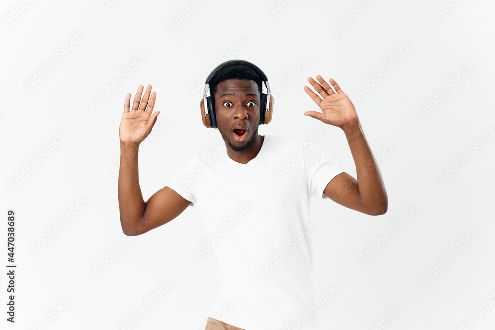 Fototapeta premium surprised African American wearing headphones music emotion entertainment light background