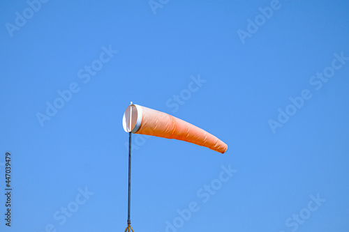 orange wind sock flying in the wind to show wind direction
