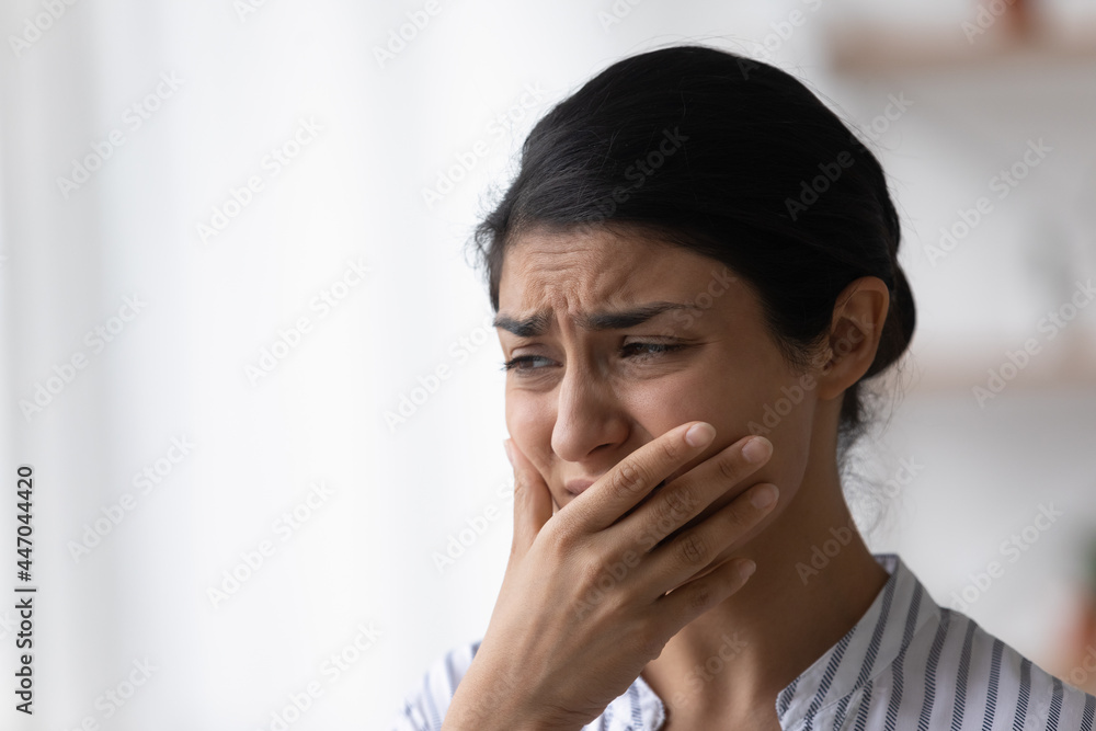 Close up of depressed frustrated Indian woman crying, feeling anxiety, upset sad young female feeling panic attack, covering face with hand, thinking about problems, suffering from migraine Close up of depressed frustrated Indian woman crying, feeling anxiety, upset sad young female feeling panic attack, covering face with hand, thinking about problems, suffering from migraine