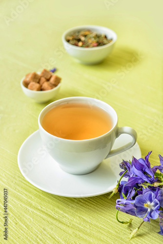 Composition with cup of floral tea on color wooden background