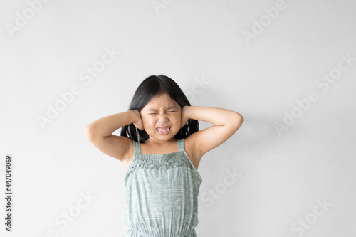 Asian child or kid girl hand covering ears and close eye to angry with scared or stress expression and loud noises concept on white bcakground isolated photo