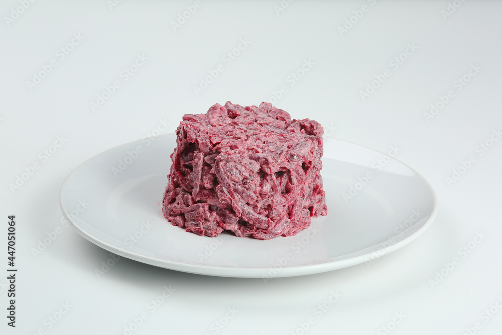 beet and garlic mayonnaise salad on white plate. beet salad isolated on white background