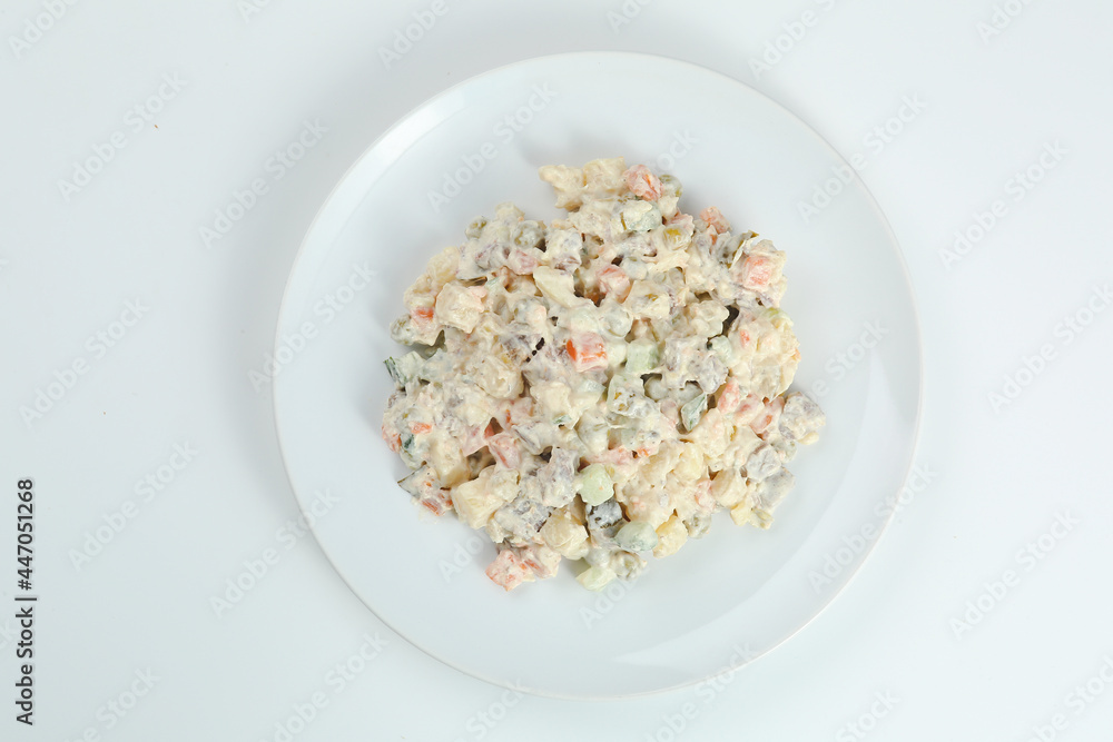 Olivier salad on white plate. vegan version of traditional russian salad Olivier from boiled vegetables. Olivier salad on white plate. vegan version of traditional russian salad Olivier from boiled vegetables.
