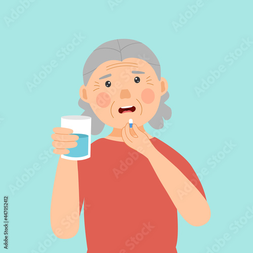 Senior woman taking medicine for illness treatment. Old woman take vitamin or supplement capsule pill with water.