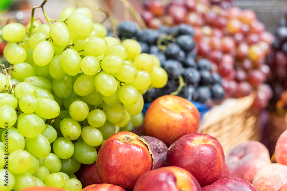 Nectarines, peaches, grapes are laid out in slides on the counter of the store Nectarines, peaches, grapes are laid out in slides on the counter of the store