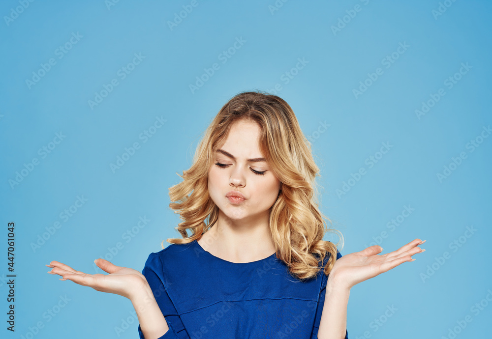pretty blonde in a blue dress gesturing with her hands emotions blue background pretty blonde in a blue dress gesturing with her hands emotions blue background
