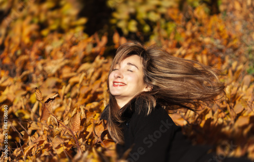 Happy girl portrait with autumn leaves