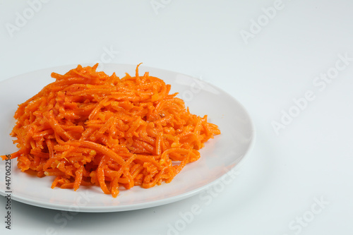 Korean carrots salad closeup in white plate isolated on white background. traditional Korean salad with carrot
