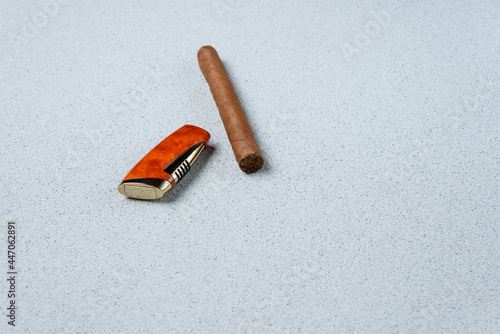 Lighter and cigar on a concrete table.