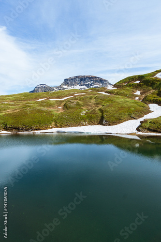 The toggia lake: one of the many alpine lakes full of snow and ice that melts during the end of spring, near the town of Riale, Italy - June 2021.
