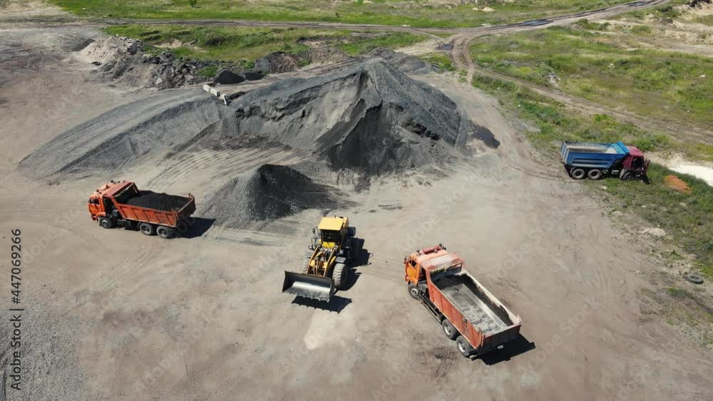a loader carries rubble in a bucket. aerial shooting. a loader carries rubble in a bucket. aerial shooting.