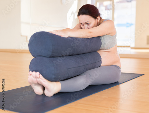 Pregnant woman is engaged in yoga. Seated Forward Fold or Paschimottanasana