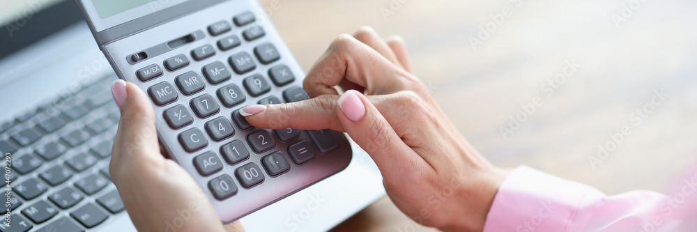 Woman's finger presses button on calculator closeup Woman's finger presses button on calculator closeup