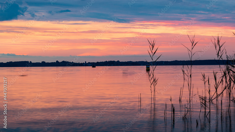 Scenic view of orange sunset sky over lake Chiemsee, Germany. in summer. Romantic evening sky at tranquil destination Scenic view of orange sunset sky over lake Chiemsee, Germany. in summer. Romantic evening sky at tranquil destination