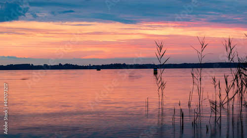 Scenic view of orange sunset sky over lake Chiemsee  Germany. in summer. Romantic evening sky at tranquil destination