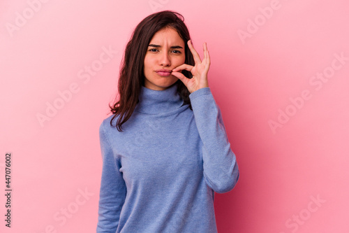 Young caucasian woman isolated on pink background with fingers on lips keeping a secret.