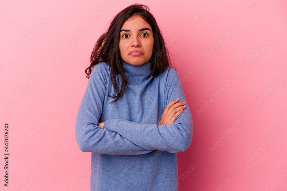 Young caucasian woman isolated on pink background shrugs shoulders and open eyes confused. Young caucasian woman isolated on pink background shrugs shoulders and open eyes confused.